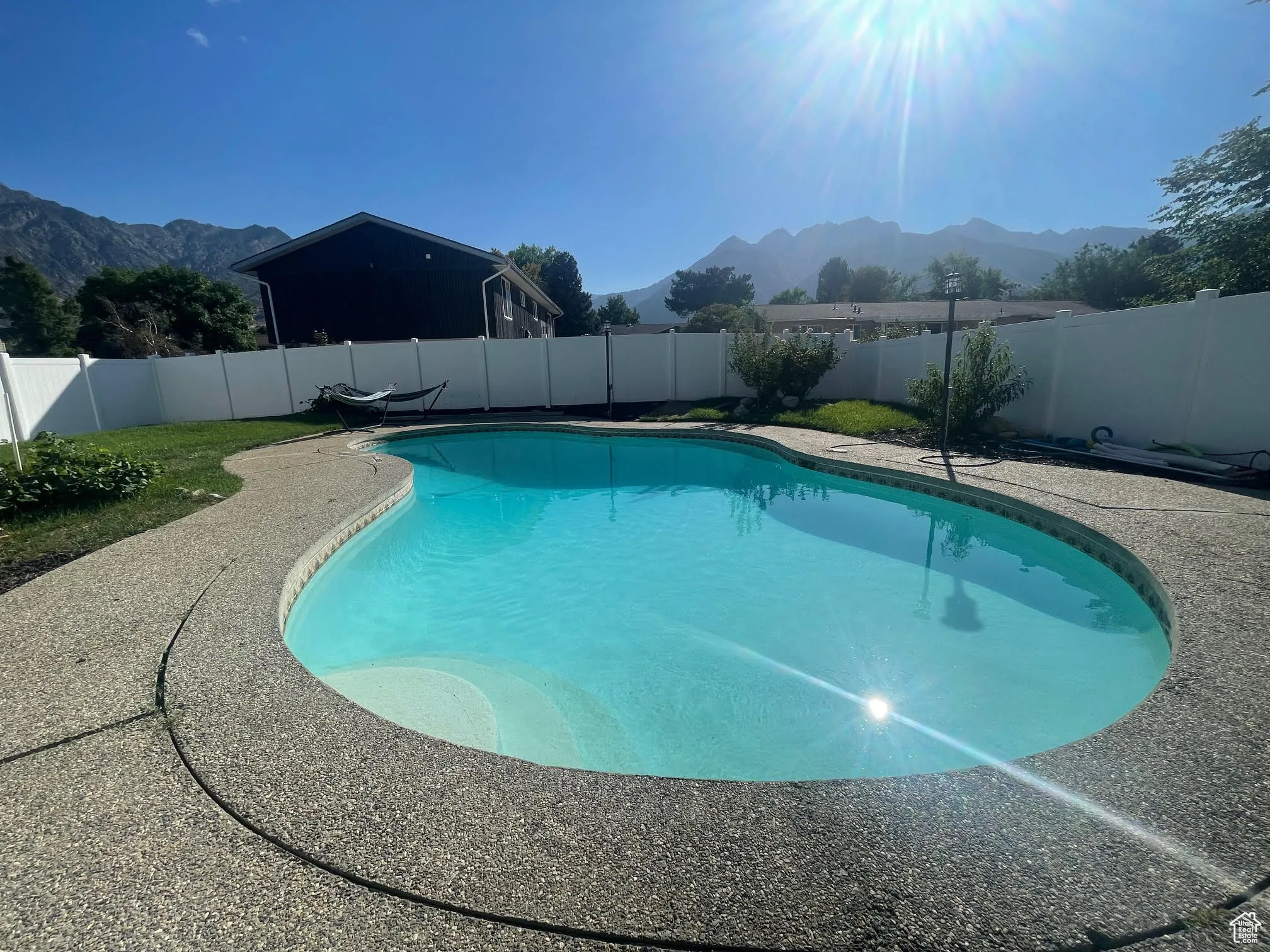 View of swimming pool featuring a mountain view, a fenced backyard, and a patio
