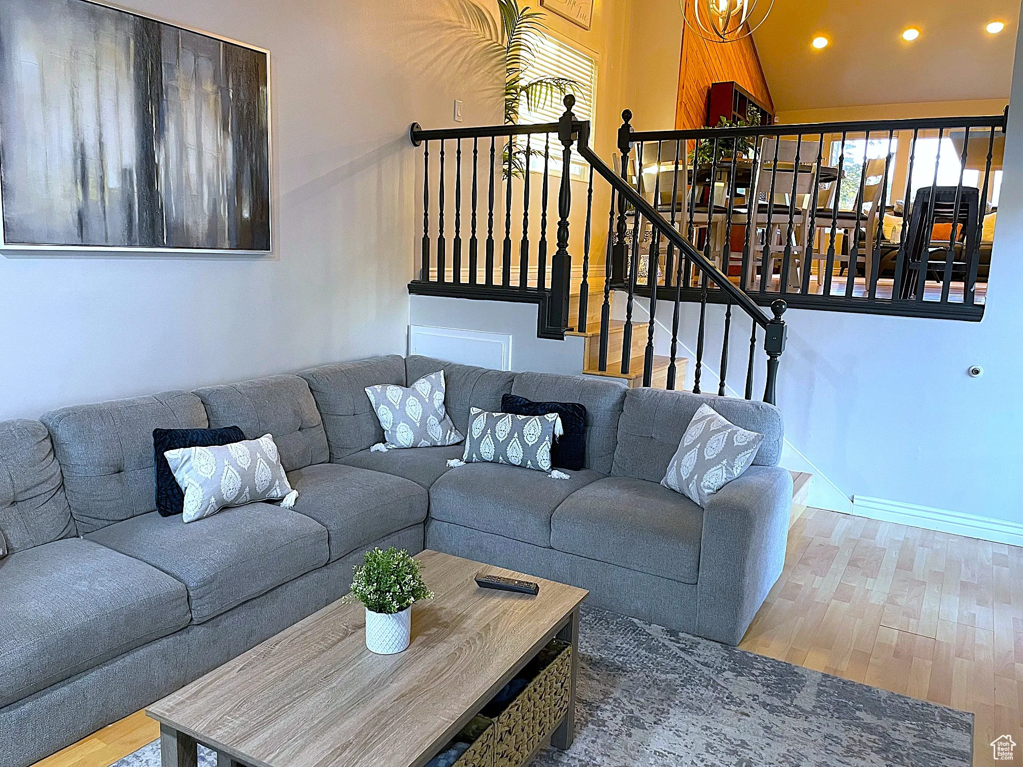 Living room with light wood-style floors, a chandelier, recessed lighting, and stairway
