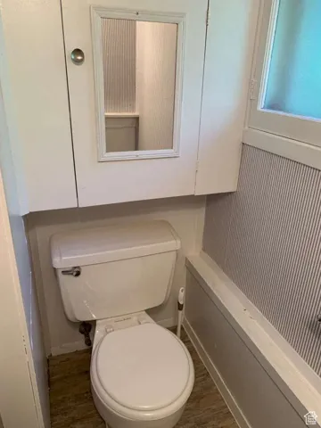 Bathroom featuring dark wood-type flooring and toilet