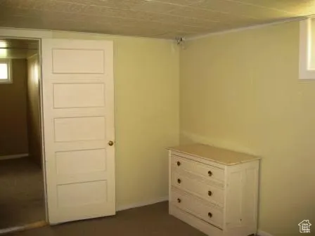 Bedroom featuring baseboards and dark colored carpet