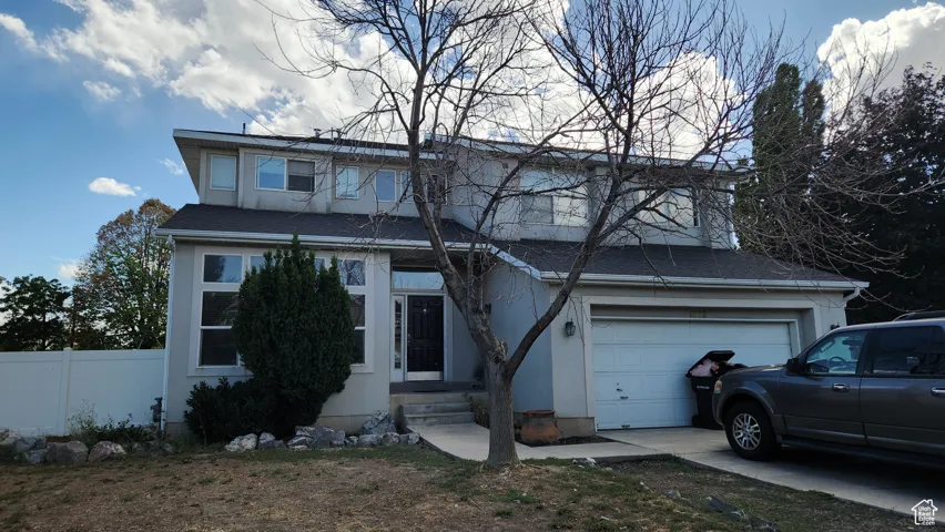View of front of house with a garage, concrete driveway, a shingled roof, and stucco siding