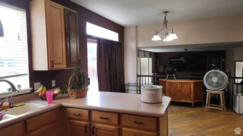 Kitchen featuring healthy amount of natural light, pendant lighting, a peninsula, and light countertops