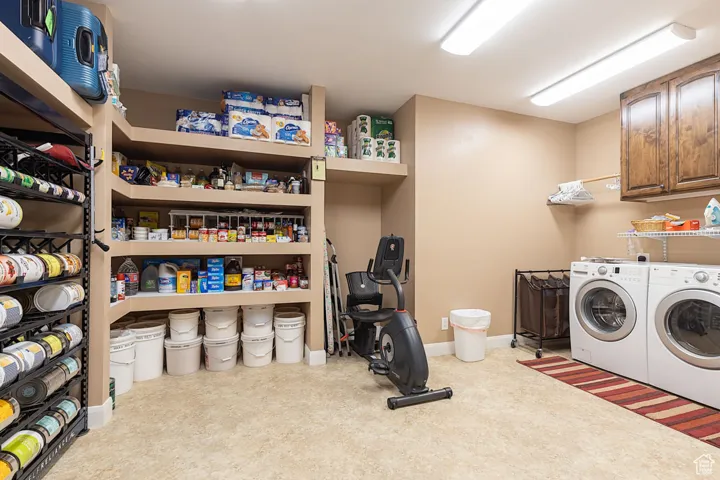 Washroom featuring separate washer and dryer and cabinet space
