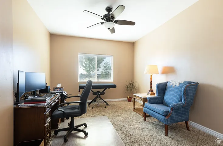 Office space with light colored carpet and ceiling fan