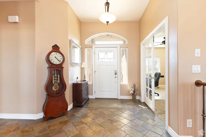 Foyer entrance featuring stone tile floors and a ceiling fan
