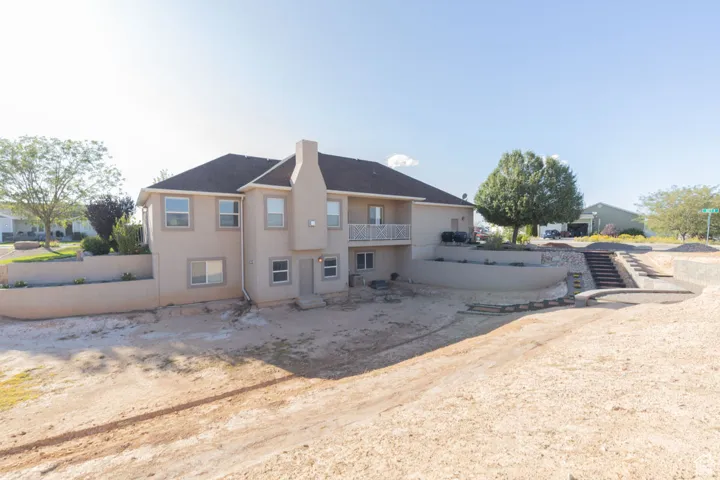 Rear view of house with a balcony and stucco siding