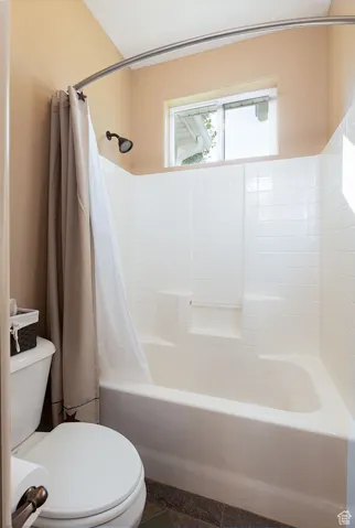 Full bath featuring shower / tub combo and toilet