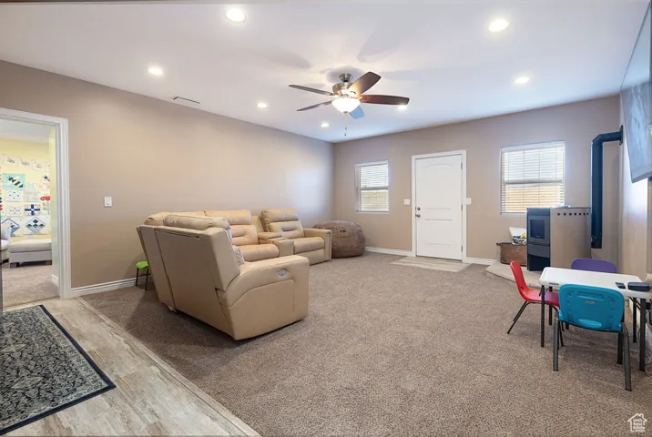 Living room with ceiling fan, recessed lighting, light carpet, and light wood-style floors