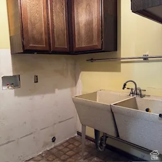 Washroom featuring hookup for a washing machine and cabinet space