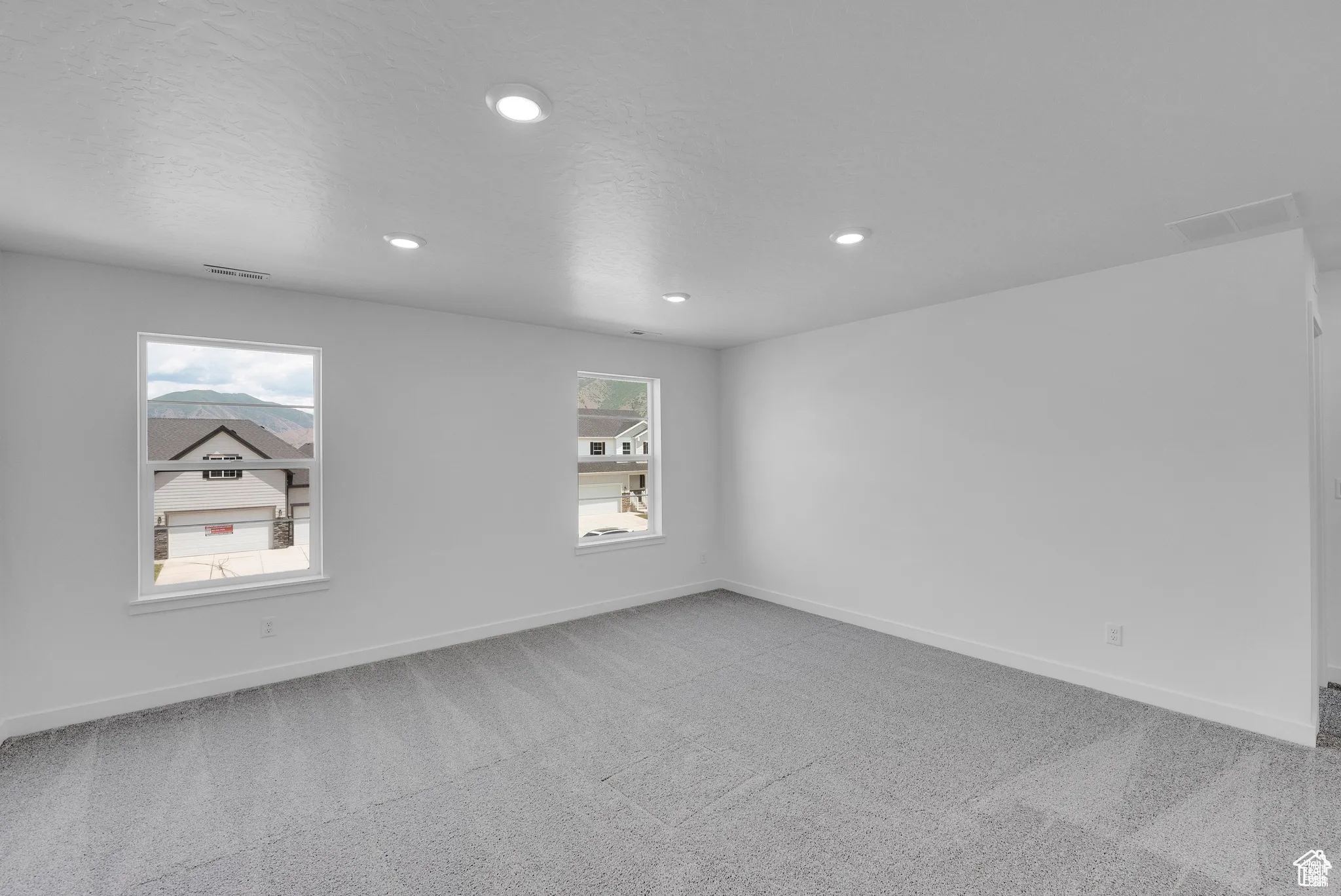 Spare room featuring light colored carpet, recessed lighting, and a textured ceiling