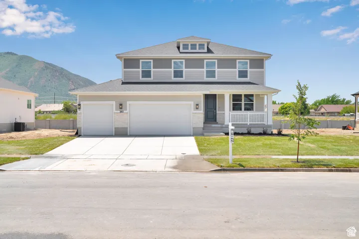 American foursquare style home with a porch, a garage, and driveway