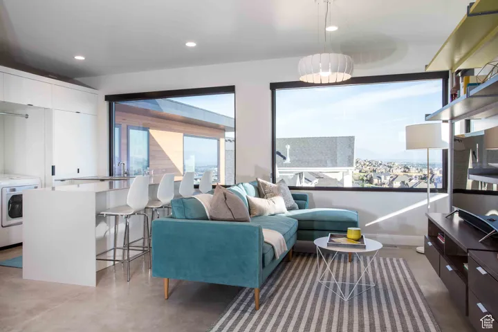 Living room with concrete floors, recessed lighting, and washer / clothes dryer