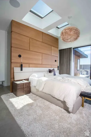 Bedroom featuring a skylight and finished concrete floors