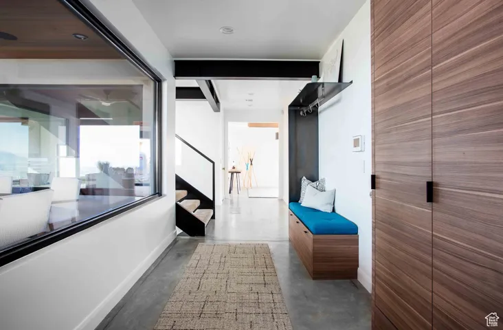 Mudroom with finished concrete floors and baseboards