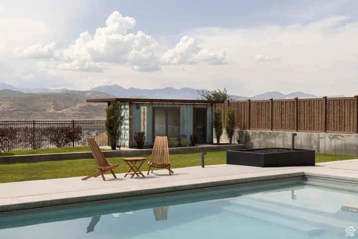 View of pool featuring a patio area, a mountain view, and an outbuilding