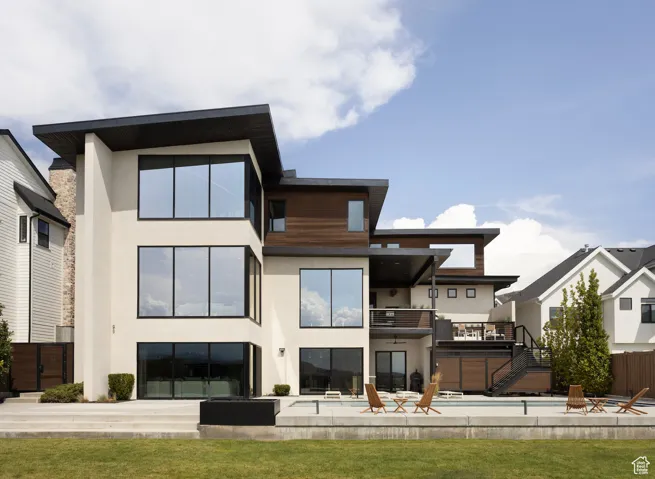 Back of property featuring stucco siding, a swimming pool, a patio, and a balcony