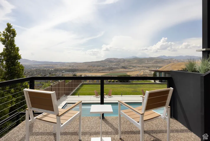 Balcony with a mountain view and view of pool area