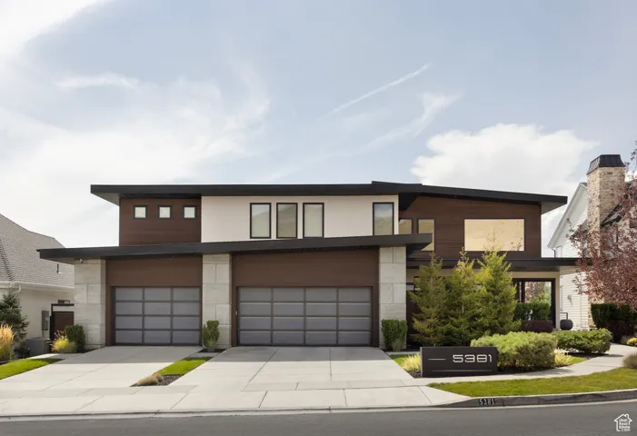 Modern home featuring a garage and concrete driveway