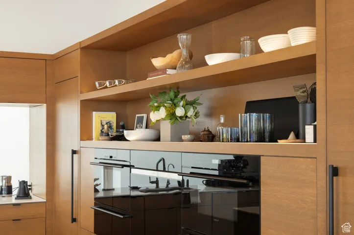 Detailed view of modern cabinets, brown cabinetry, and dark countertops
