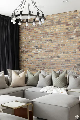 Living area featuring brick wall and a chandelier