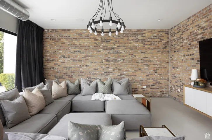 Living room with brick wall and a chandelier