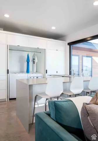 Living area featuring recessed lighting and finished concrete floors
