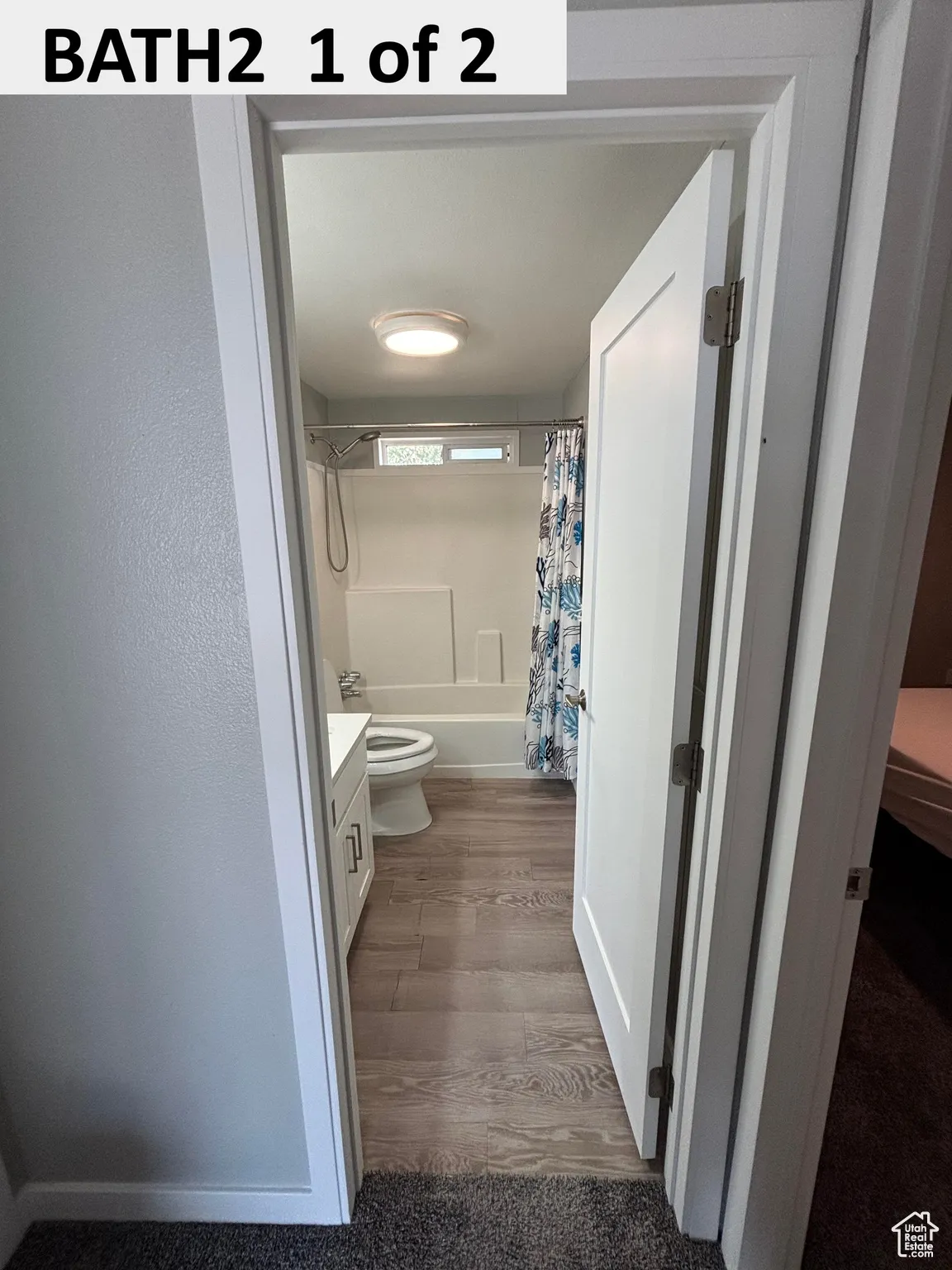 Full bathroom featuring vanity, shower/bathtub combination with dark wood-type flooring