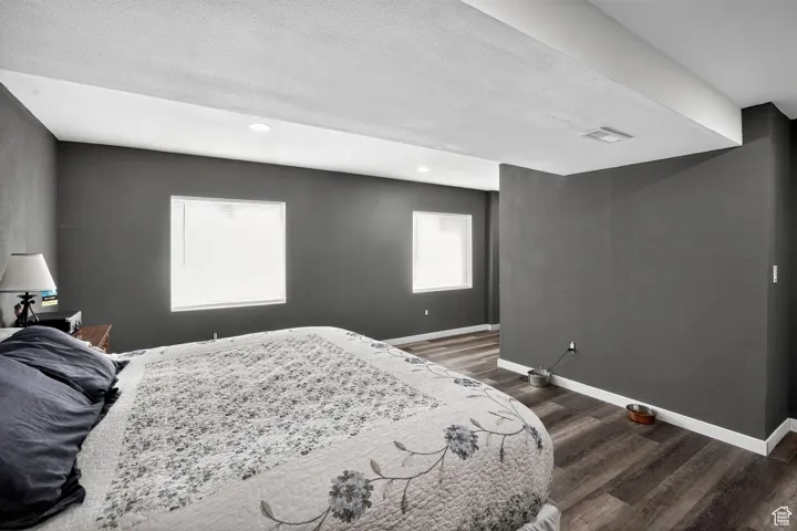 Bedroom featuring a textured ceiling, dark wood finished floors, and recessed lighting