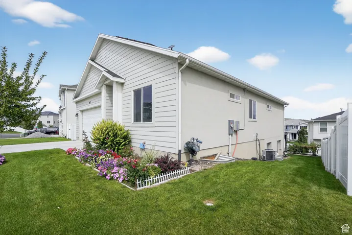 View of side of home featuring driveway and a garage