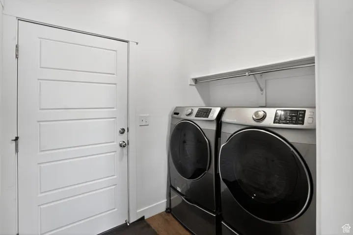 Laundry room featuring washing machine and dryer and dark wood finished floors