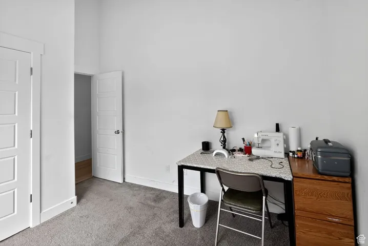 Home office with light colored carpet and baseboards