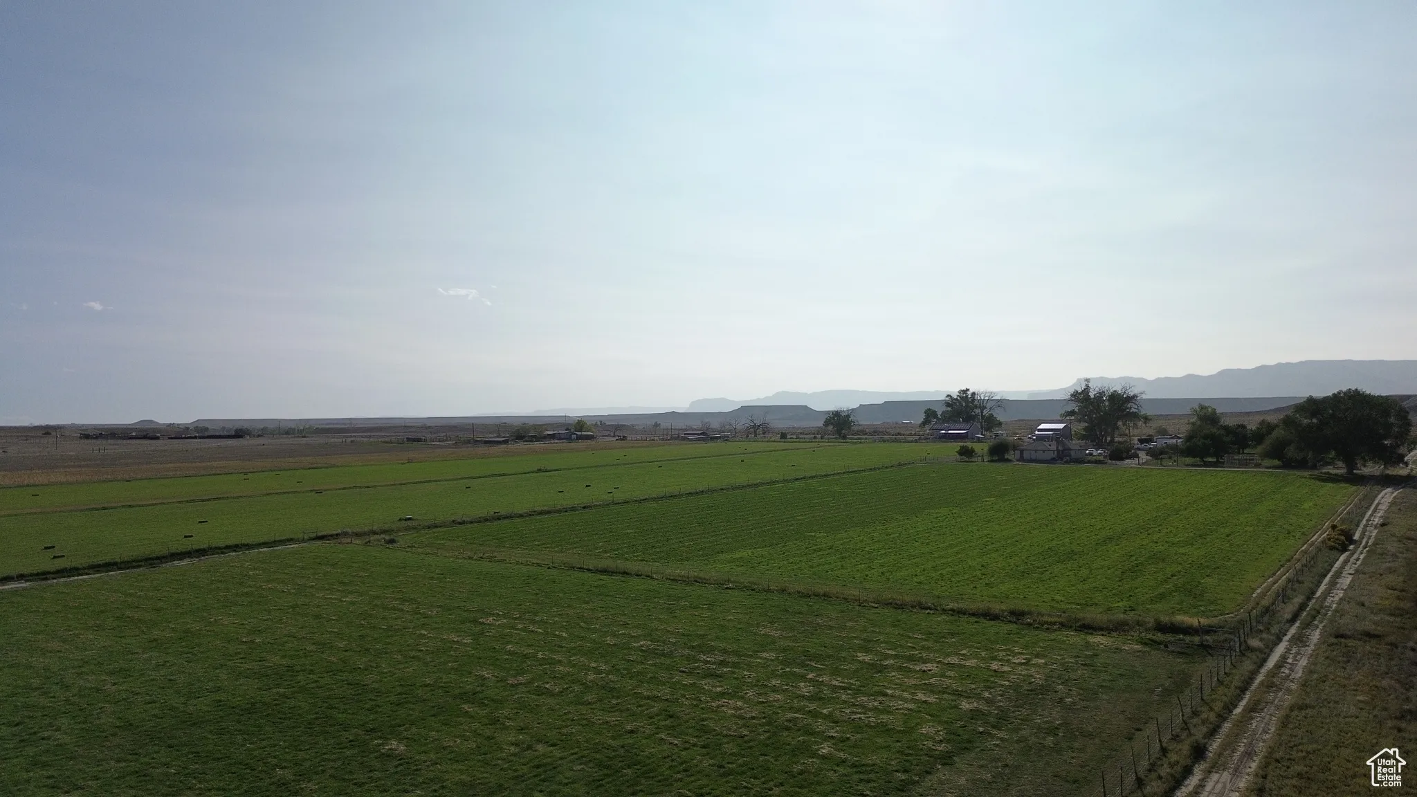 View of green lawn with a mountain view, a view of countryside, and agricultural plots