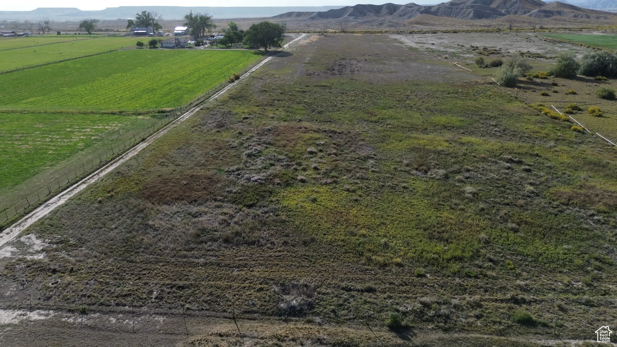 Aerial view of property's location with rural landscape and a mountain backdrop