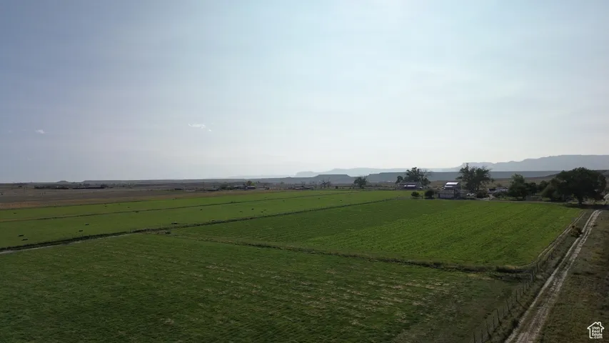 View of green lawn with a mountain view, a view of countryside, and agricultural plots