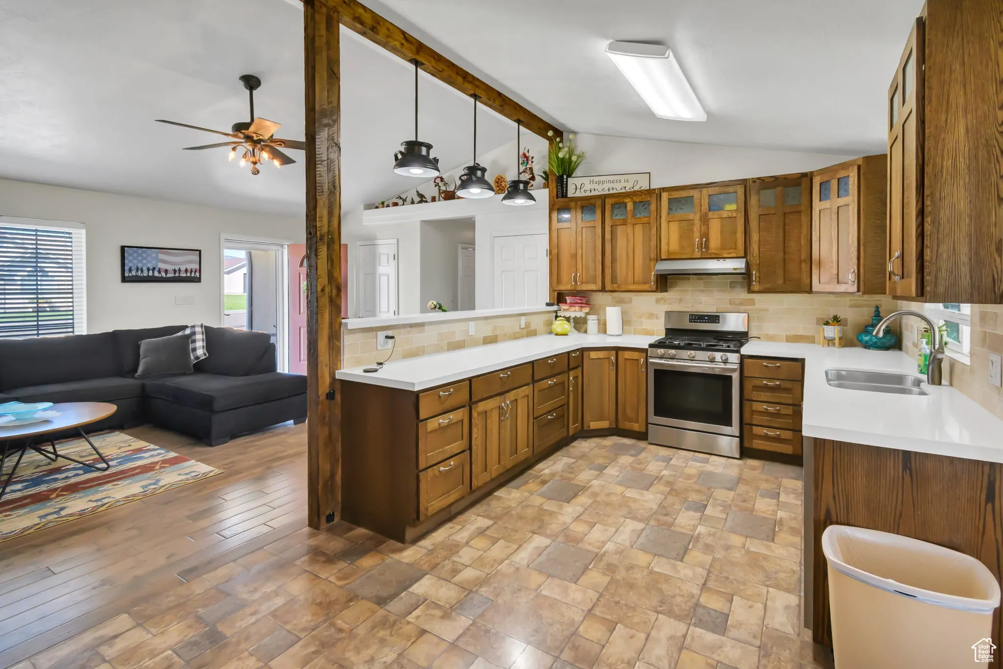 Kitchen featuring tasteful backsplash, stainless steel range with gas cooktop, open floor plan, and healthy amount of natural light