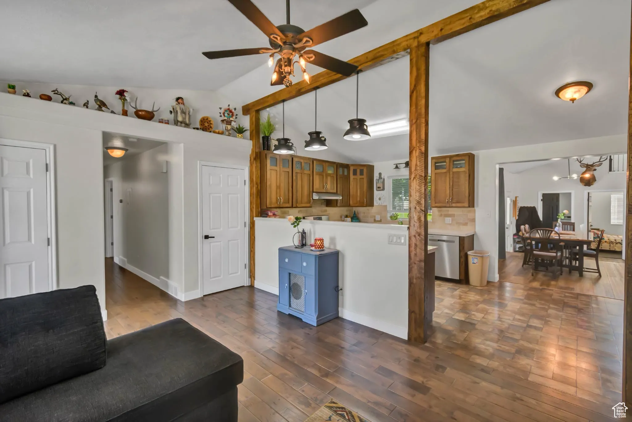 Living area with a chandelier, dark wood-style floors, and a ceiling fan
