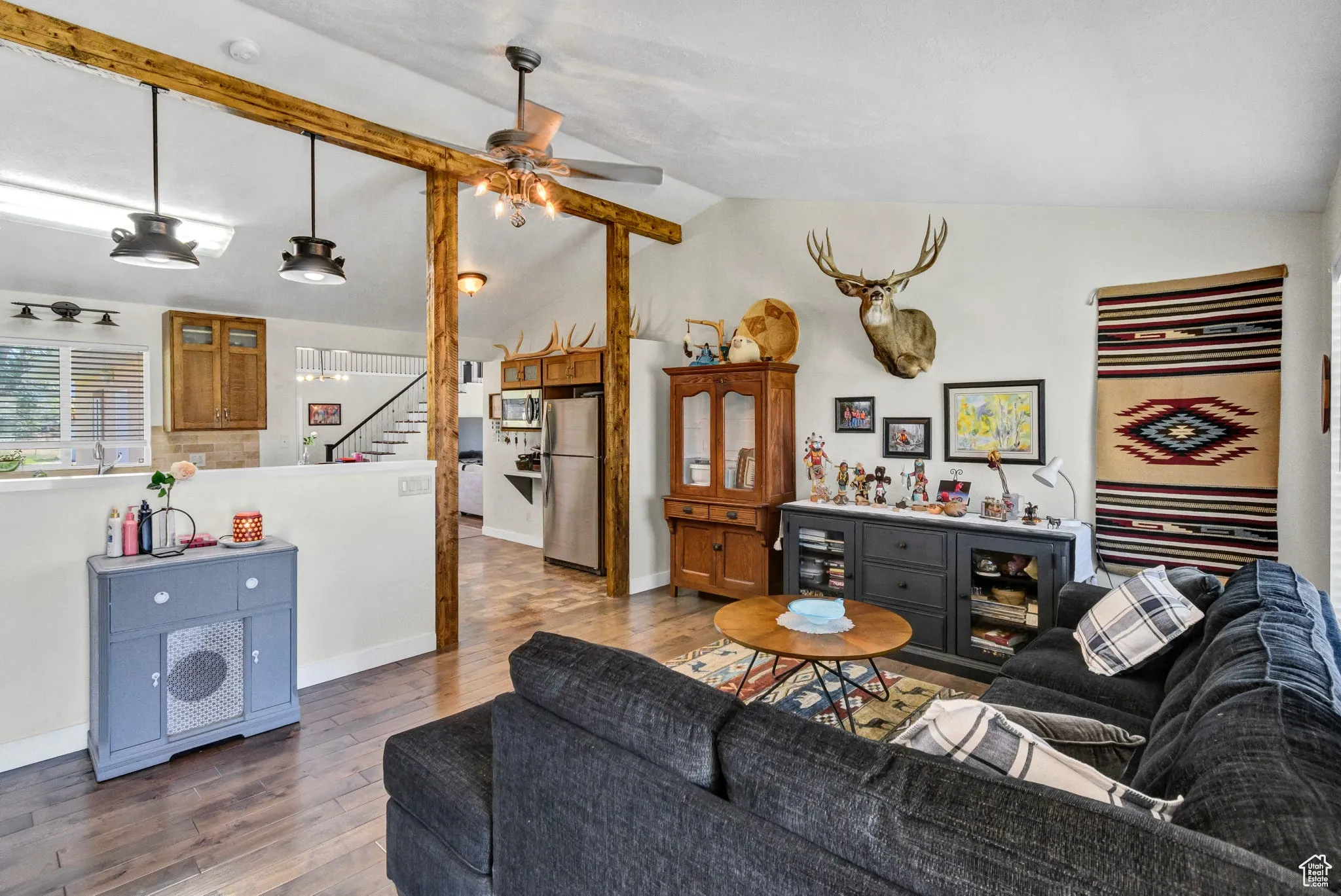 Living area featuring vaulted ceiling, wood finished floors, and a ceiling fan