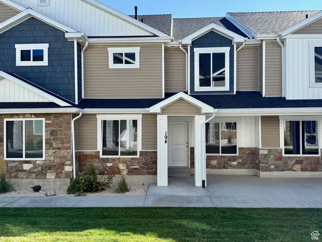 Craftsman house with a front lawn, stone siding, board and batten siding, and roof with shingles