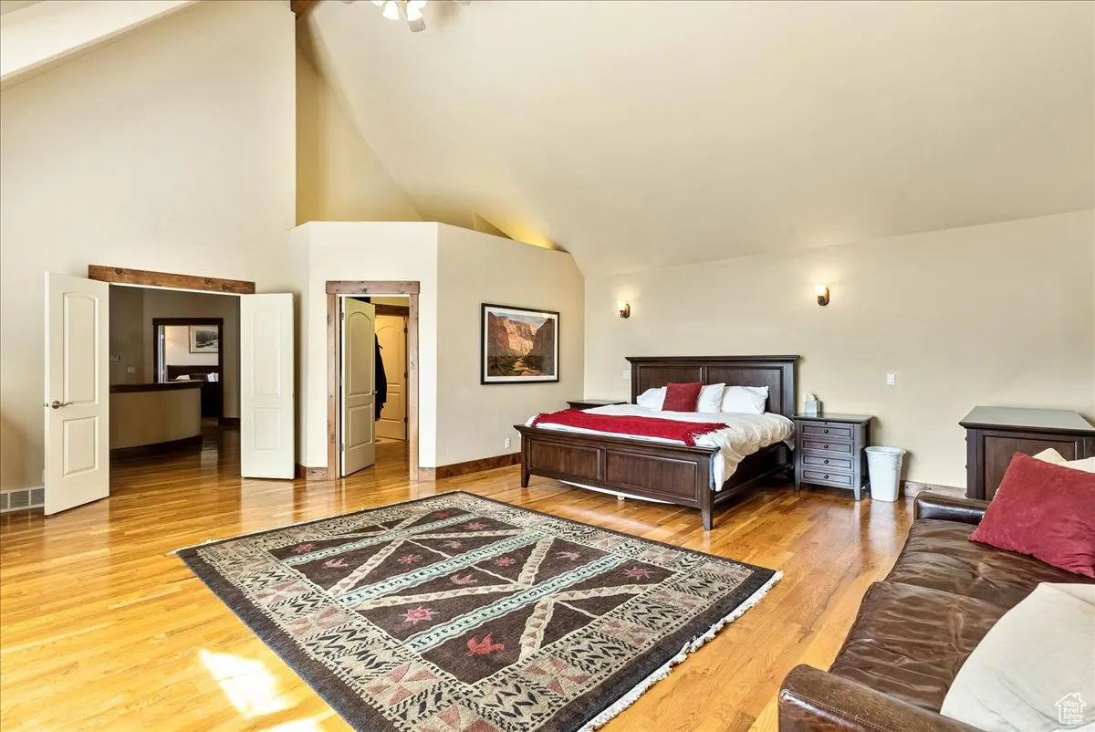 Bedroom featuring high vaulted ceiling and light wood-style flooring