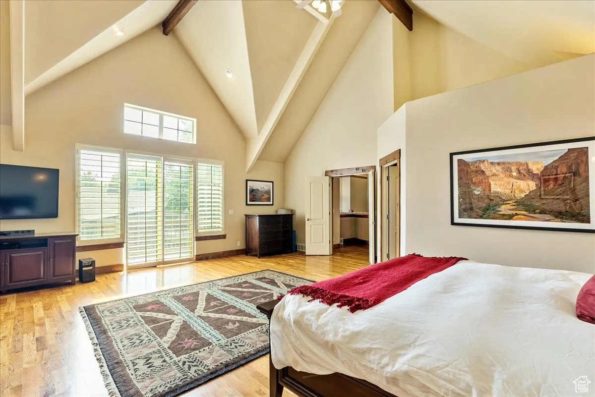Bedroom with high vaulted ceiling, light wood-style flooring, beamed ceiling, and recessed lighting