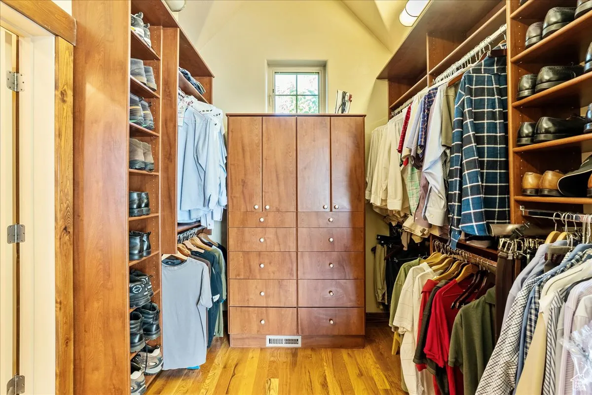 Walk in closet with light wood-type flooring