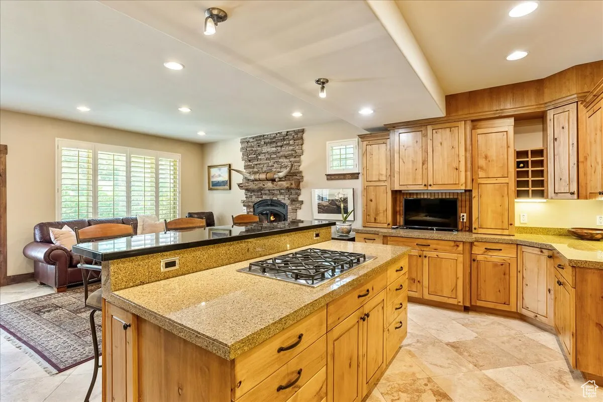 Kitchen featuring a breakfast bar area, open floor plan, recessed lighting, stainless steel gas stovetop, and a kitchen island