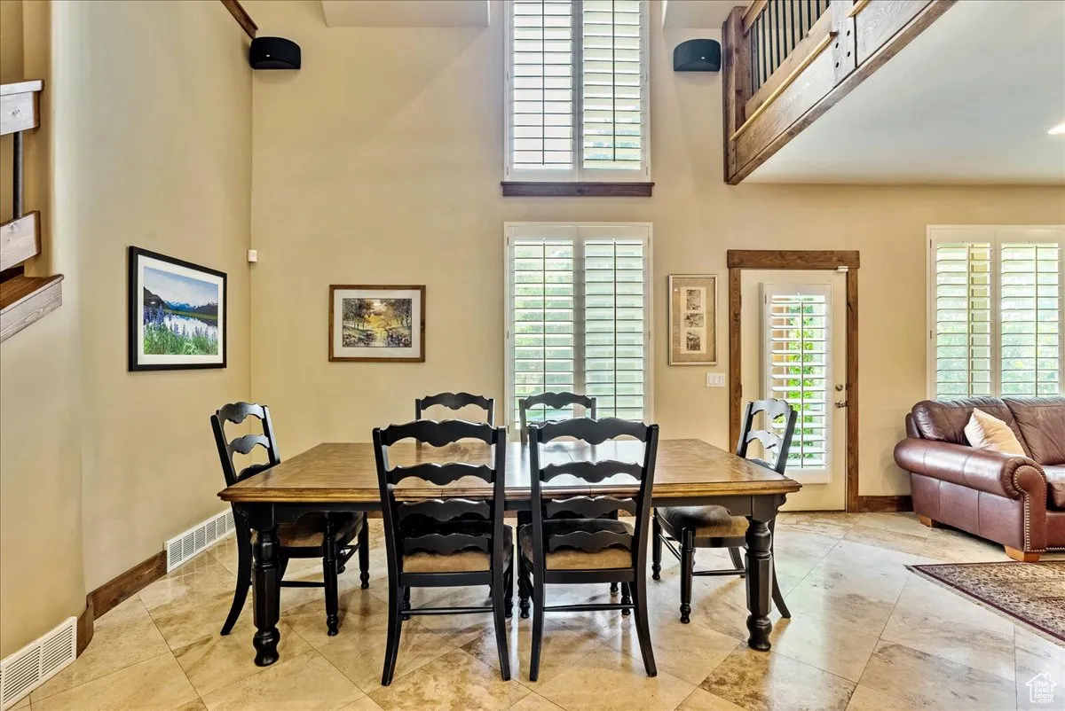 Dining area with healthy amount of natural light and a high ceiling