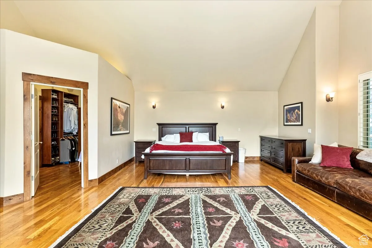 Bedroom featuring light wood-style floors and high vaulted ceiling