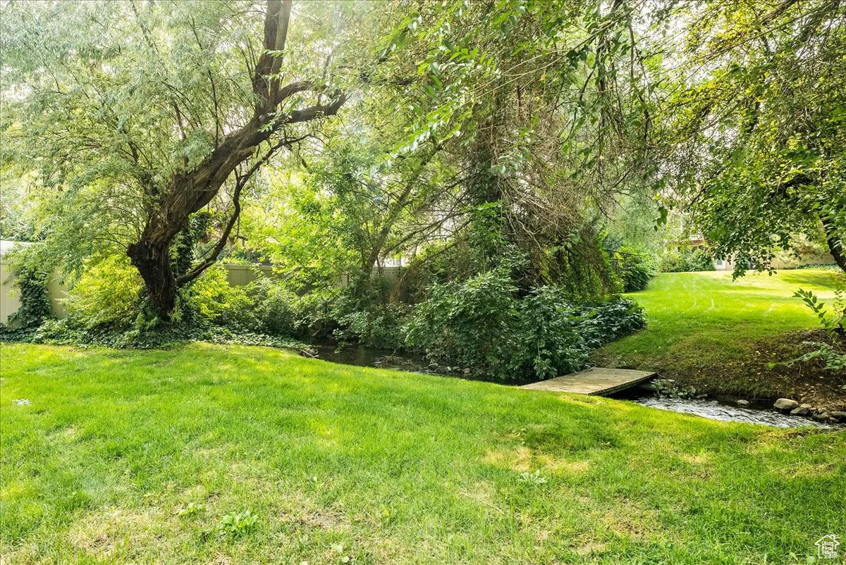 View of grassy yard with a water view