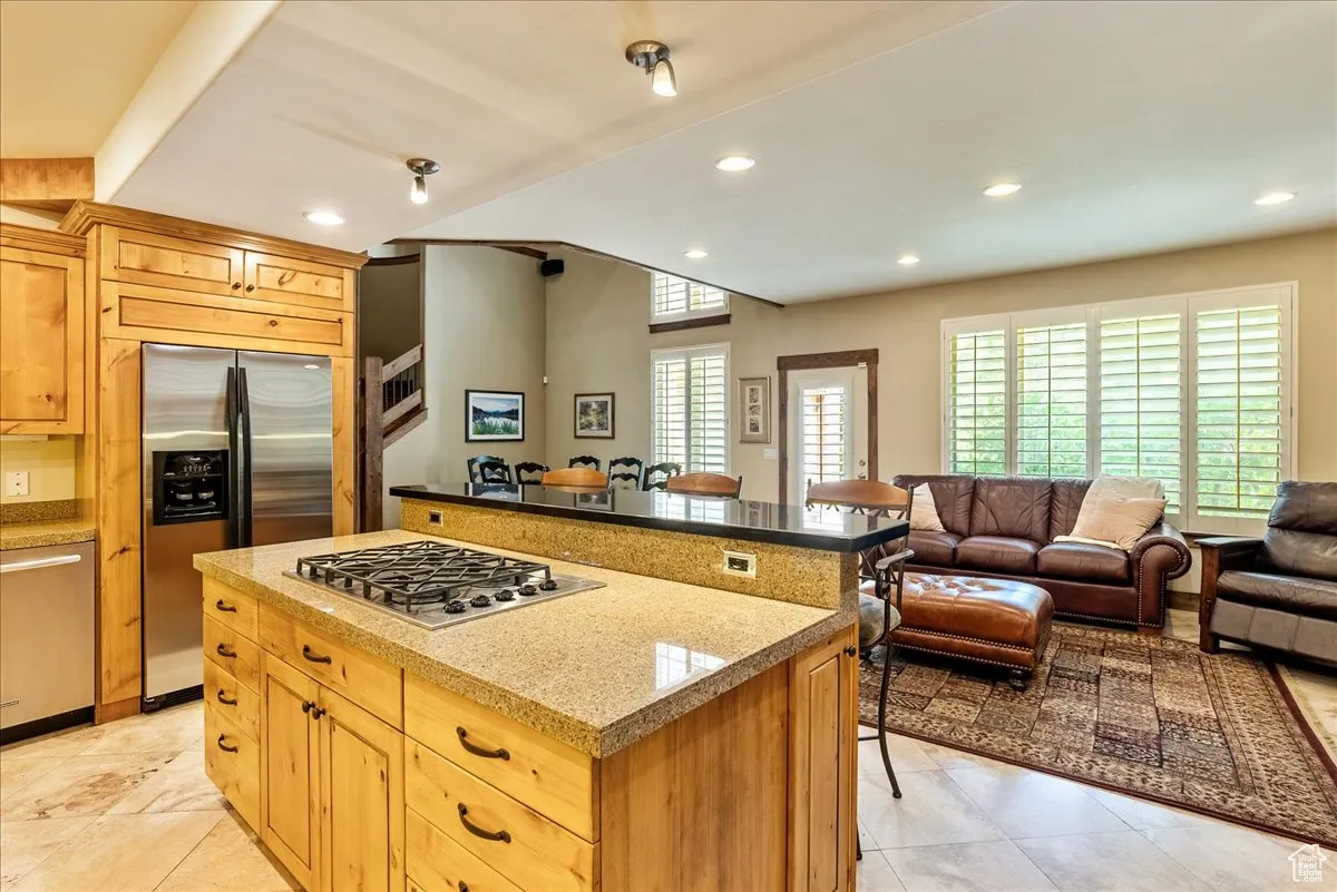 Kitchen featuring a breakfast bar area, stainless steel appliances, open floor plan, recessed lighting, and a kitchen island