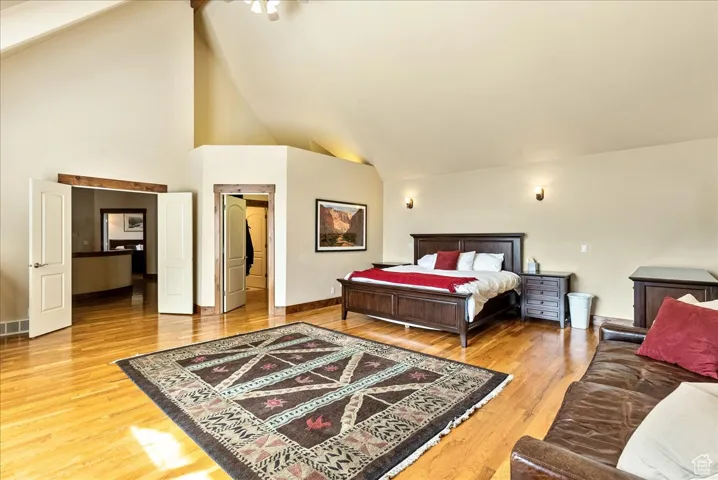 Bedroom featuring high vaulted ceiling and light wood-style flooring