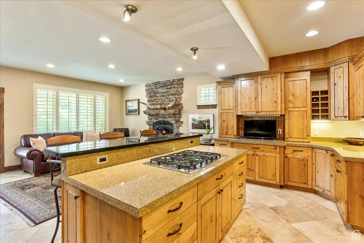 Kitchen featuring a breakfast bar area, open floor plan, recessed lighting, stainless steel gas stovetop, and a kitchen island