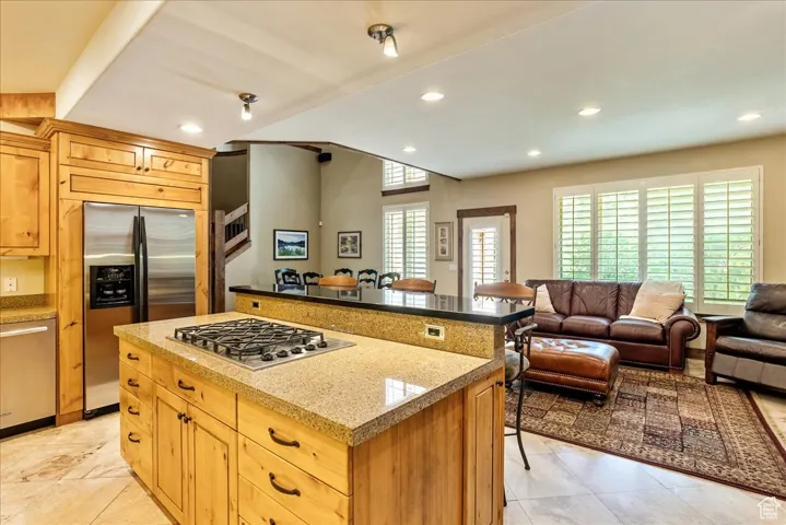 Kitchen featuring a breakfast bar area, stainless steel appliances, open floor plan, recessed lighting, and a kitchen island