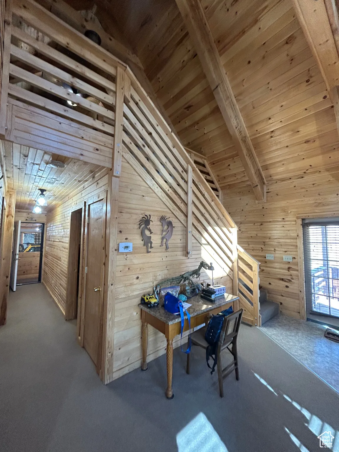 Office area with wood walls, wooden ceiling, and carpet flooring